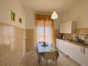 a kitchen with a table and a dining room at Guest House Service - Express Airport Apartment in Modugno