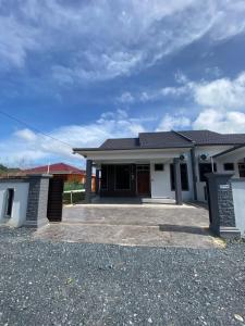a house with a driveway in front of it at afza Homestay Paka A in Paka