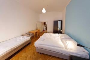 a bedroom with two beds and a table in it at Apartments Truhlarska 31 in Prague