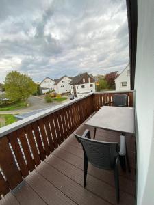 a balcony with a table and chairs on a deck at Ferienwohnung Bussard in Patersberg