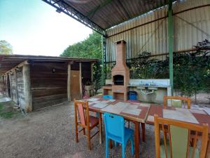 uma mesa de madeira com cadeiras e um fogão a lenha em La Villa Chalés Garden em Serra Negra