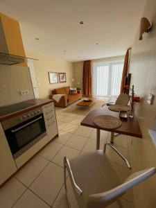 eine Küche und ein Wohnzimmer mit einem Tisch und einem Sofa in der Unterkunft Lakeview Appartements in Zeuthen