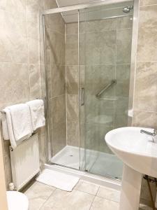 a bathroom with a shower and a sink at Dergvale Hotel in Dublin