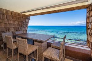 カハナにあるDirect Oceanfront Views Modern Penthouse in Paradiseの海が見えるバルコニーにテーブルと椅子がある