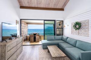 カハナにあるDirect Oceanfront Views Modern Penthouse in Paradiseの青いソファとテーブルのあるリビングルーム