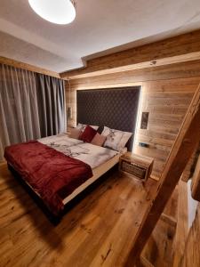 sypialnia z łóżkiem w pokoju z drewnianą podłogą w obiekcie Panorama Berg Chalet w mieście Großkirchheim