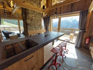 una cocina con encimera y taburetes en una cabaña en Panorama Berg Chalet, en Großkirchheim