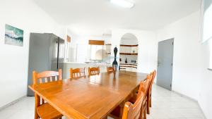 Il comprend une cuisine et une salle à manger avec une table et des chaises en bois. dans l'établissement Vila Ricardo by Sunny Deluxe, à Albufeira