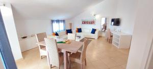 - une salle à manger et un salon avec une table et des chaises dans l'établissement Branco Suites - Rooms & Holiday Apartments, à Santa Maria