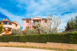 a house with a hedge in front of a house at Apartments Lorena in Poreč