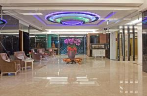 - un hall doté d'un grand plafond violet avec des chaises et des fleurs dans l'établissement Renyi Lake Hotel, à Fanlu