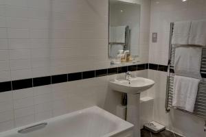 a white bathroom with a sink and a bath tub at Best Western Ship Hotel in Weybridge