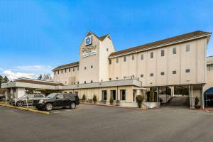 a large building with a car parked in a parking lot at SureStay Hotel by Best Western SeaTac Airport North in SeaTac