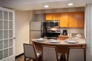 uma cozinha com uma mesa com cadeiras e um frigorífico em Sonesta ES Suites Tempe em Tempe