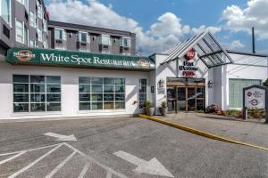 Best Western Plus Vancouver Airport Hotel في فانكوفر: مطعم بقعة بيضاء في موقف للسيارات