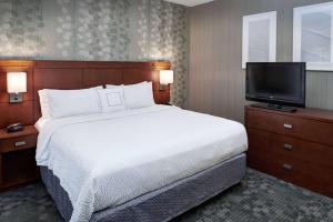 a bedroom with a bed and a flat screen tv at Sonesta Select Milwaukee Brookfield in Brookfield +20 photos