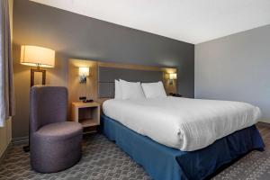 a hotel room with a large bed and a chair at Best Western Plus Vancouver Airport Hotel in Vancouver