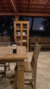 a table with two wine glasses and a bottle of wine at Pousada Chalés Praia Vermelha in São João Batista do Glória