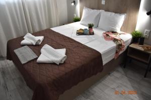 a bedroom with a large bed with towels on it at Le An Apartments Thalassa in Keramotí