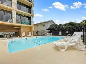 a swimming pool with chairs and a whitevisorvisor at Sea Life - OCEANFRONT! Pleasure Island Paradise! Lose yourself in the ocean views! condo in Carolina Beach