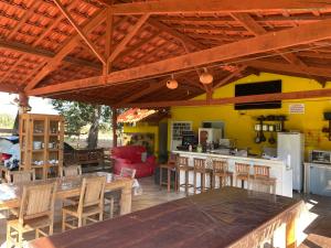an outdoor kitchen with tables and chairs and a bar at Pousada Chalés Praia Vermelha in São João Batista do Glória