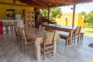 a wooden table and chairs on a patio at Pousada Chalés Praia Vermelha in São João Batista do Glória