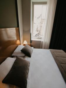 two beds in a room with a window at Hotel Astra in Sarajevo