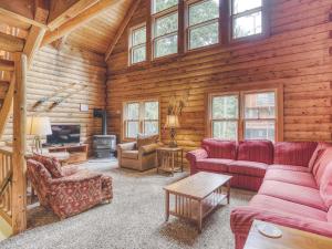 een woonkamer met rode meubels in een blokhut bij Cedarwood Lodge in Government Camp