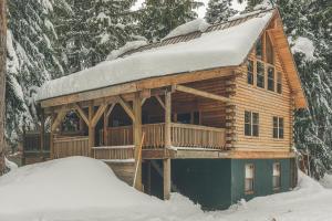 een blokhut met sneeuw erop bij Cedarwood Lodge in Government Camp