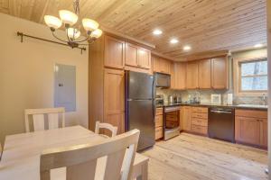 a kitchen with wooden cabinets and a table and a refrigerator at River Breeze Chalet in Rhododendron