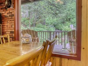 a table with a vase on it on a porch at Storybrooks Cabin - Meredith Lodging in Rhododendron +17 photos
