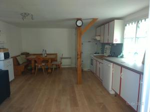 a kitchen with white cabinets and a table in it at Les Guernazelles in Bracieux