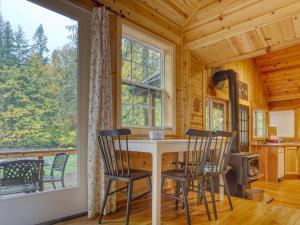 a kitchen with a table and chairs and a large window at Thistle Dew - Meredith Lodging in Welches