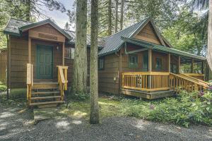 a cabin in the woods with a porch and a tree at Thistle Dew - Meredith Lodging in Welches +17 photos