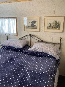 a bed with a blue and white comforter and two pillows at Jade City Bungalow in Jade City