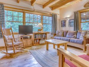 Una sala de estar con un sofá y un televisor. en Marshall Cabin - Meredith Lodging, en Government Camp
