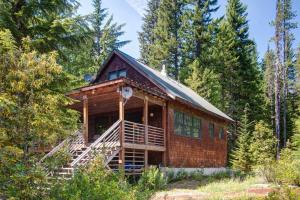 una cabaña de troncos en el bosque con árboles en Marshall Cabin - Meredith Lodging, en Government Camp