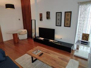 a living room with a television and a coffee table at Apartamento Un Jardin en la Alfalfa - Kainga Homes in Seville