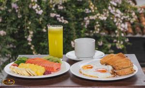 une table avec deux assiettes de nourriture et un verre de jus d'orange dans l'établissement Bello Hogar Hospedaría VDL, à Villa de Leyva