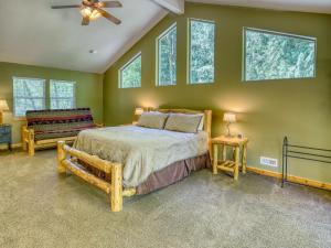 a bedroom with a bed and some windows at Salmon River Chalet - Meredith Lodging in Welches