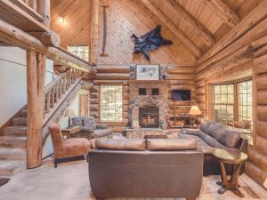 - un salon avec un canapé et une cheminée dans une cabane en rondins dans l'établissement Bear Den Log Cabin, à Welches