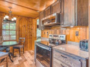 a kitchen with wooden cabinets and a stove top oven at Bridlewood Cabin - Meredith Lodging in Welches +27 photos