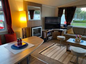 a living room with a couch and a table at Deluxe 3 bedroom caravan in Haven's Seton Sands Holiday Village,Wifi in Port Seton