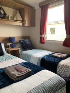 Een bed of bedden in een kamer bij Deluxe 3 bedroom caravan in Haven's Seton Sands Holiday Village,Wifi