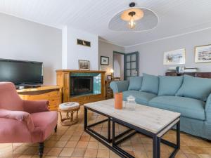 sala de estar con sofás azules y TV en Gîte Joué-sur-Erdre, 4 pièces, 5 personnes - FR-1-306-1166, en Joué-sur-Erdre