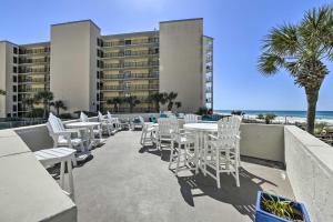 una fila di sedie e tavoli bianchi su un patio di Sandpiper Studio - Resort Pool and Beach Access! a Panama City Beach