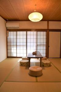 a room with a table and two stools in it at Guesthouse Hakuka in Kanazawa