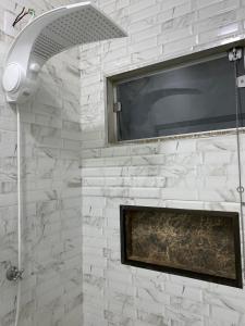 a shower with a shower head in a bathroom at Pousada Chalés Praia Vermelha in São João Batista do Glória