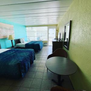 Habitación de hotel con 2 camas y mesa en Bird of Paradise Motel, en North Wildwood