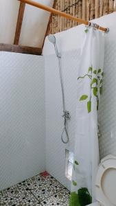 a bathroom with a shower with a toilet in it at The Pondok in Kuta Lombok